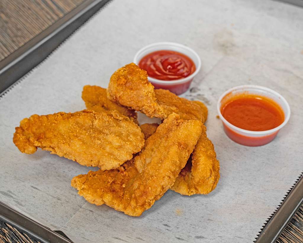Crispy chicken tenders with ketchup and hot sauce